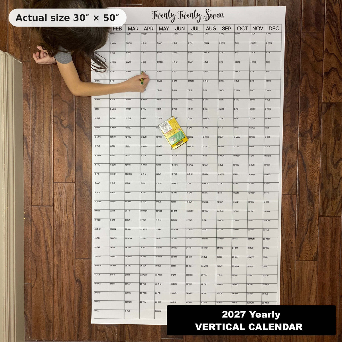 Child writing on the 2027 giant yearly wall calendar on the floor, showing its real 30 x 50 inch size