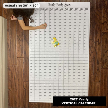 Child writing on the 2027 giant yearly wall calendar on the floor, showing its real 30 x 50 inch size