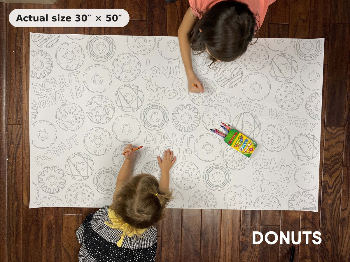 Two kids coloring the Donuts giant coloring sheet on the floor, showing its real 30 x 50 inch size
