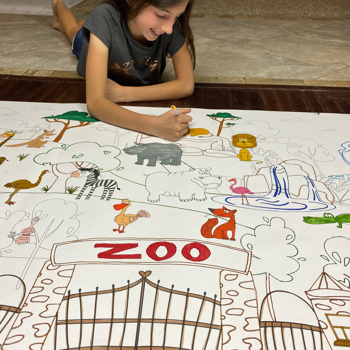 The Zoo giant coloring sheet being colored in with markers at a table