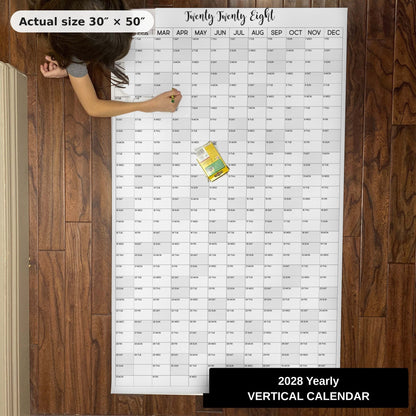 Child writing on the 2028 giant yearly wall calendar on the floor, showing its real 30 x 50 inch size