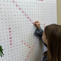 Thumbnail for Kids circling words on the Valentines Day giant word search hung on a wall