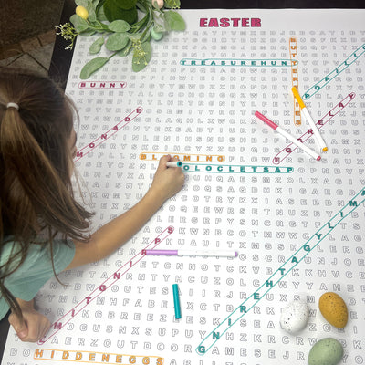 Kids circling words on the Easter giant word search at a table