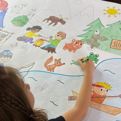 The Summer Camp giant coloring sheet being colored in with markers at a table