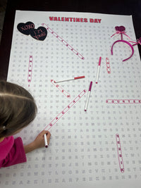 Thumbnail for Kids circling words on the Valentines Day giant word search hung on a wall