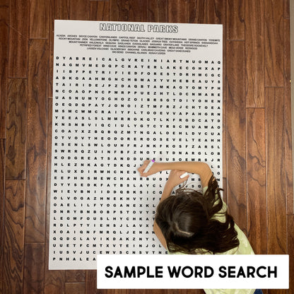 Child solving a sample giant word search from the bundle on a wood floor