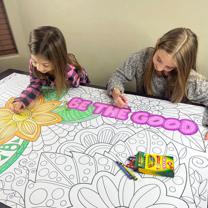 The Zentangle Be The Good giant coloring sheet being colored in with markers at a table