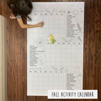 Thumbnail for A large coloring banner titled 'FALL ACTIVITY CALENDAR' laid out on a table with a child coloring it.