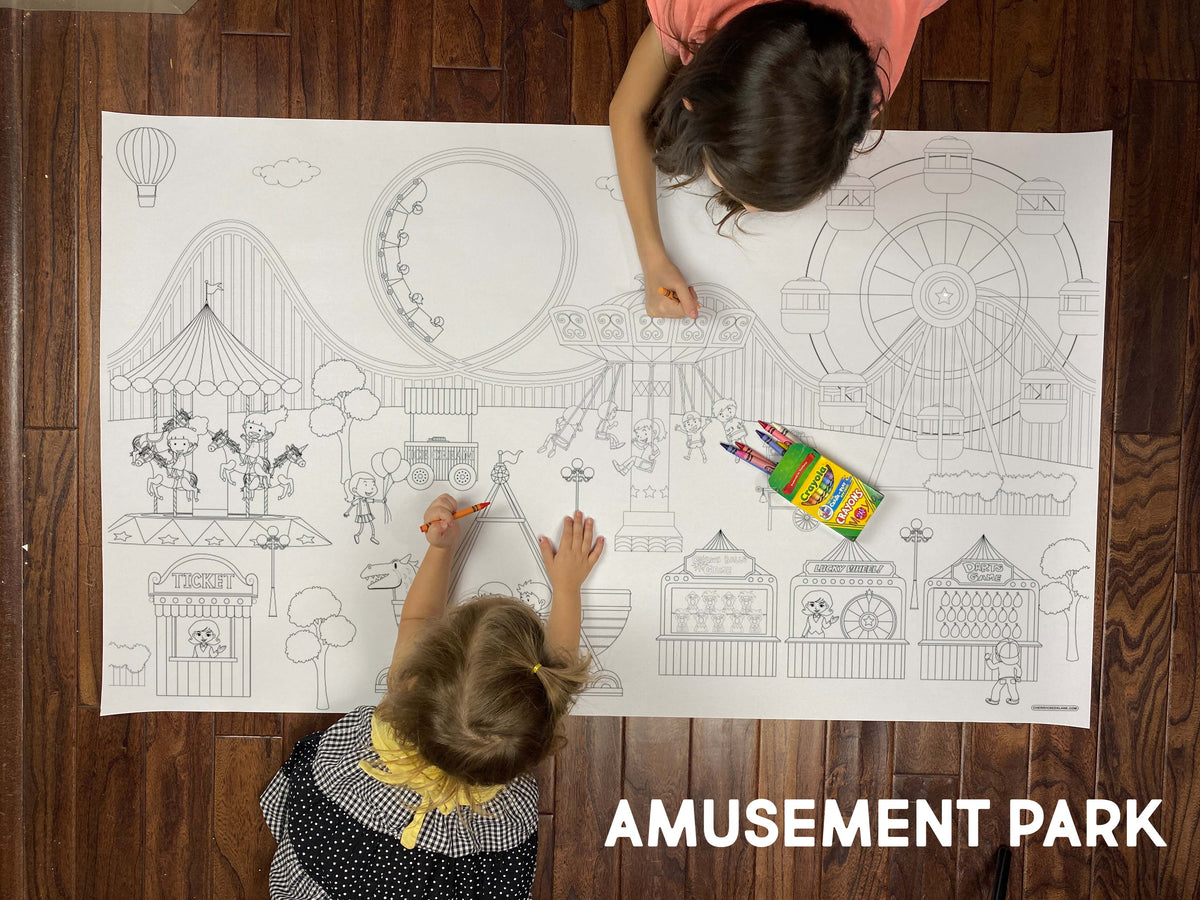 Child coloring the Amusement Park giant coloring sheet on a wood floor with crayons
