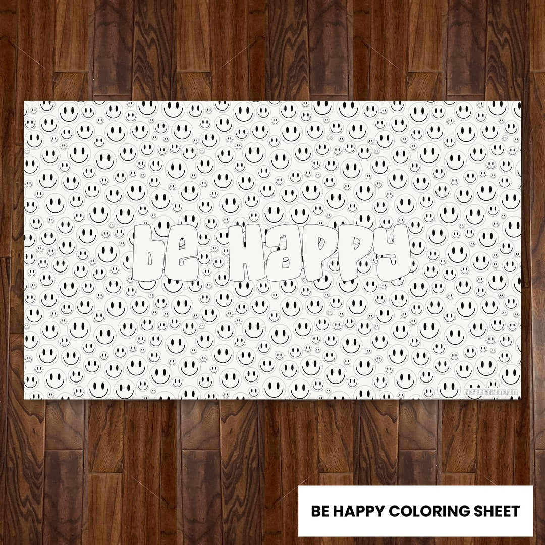 Be Happy giant 30x50 coloring sheet laid flat on a wood floor