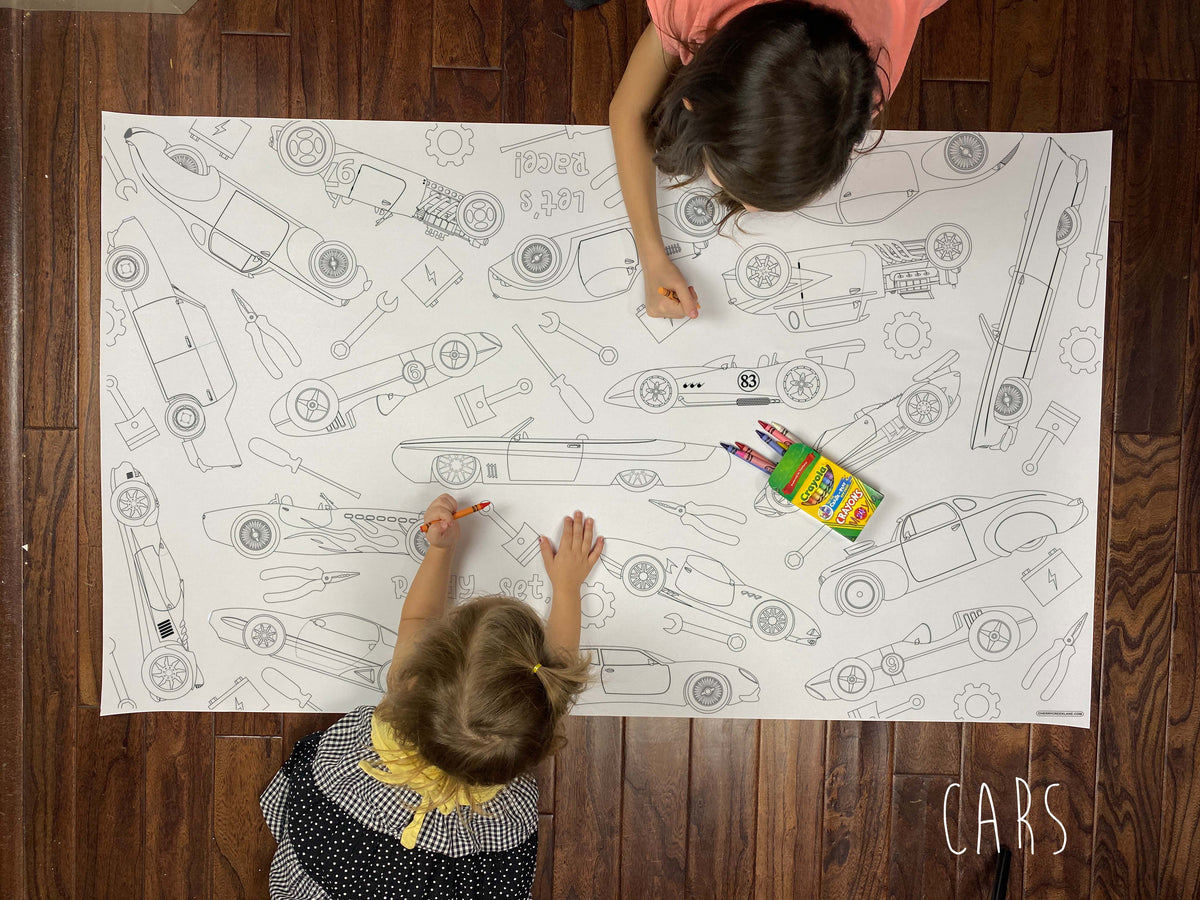 Child coloring the Cars giant coloring sheet on a wood floor with crayons
