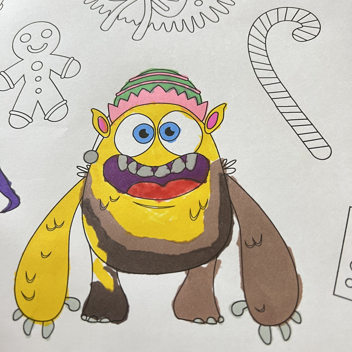 The Christmas Monsters Table Size Coloring Sheet being colored by kids at home