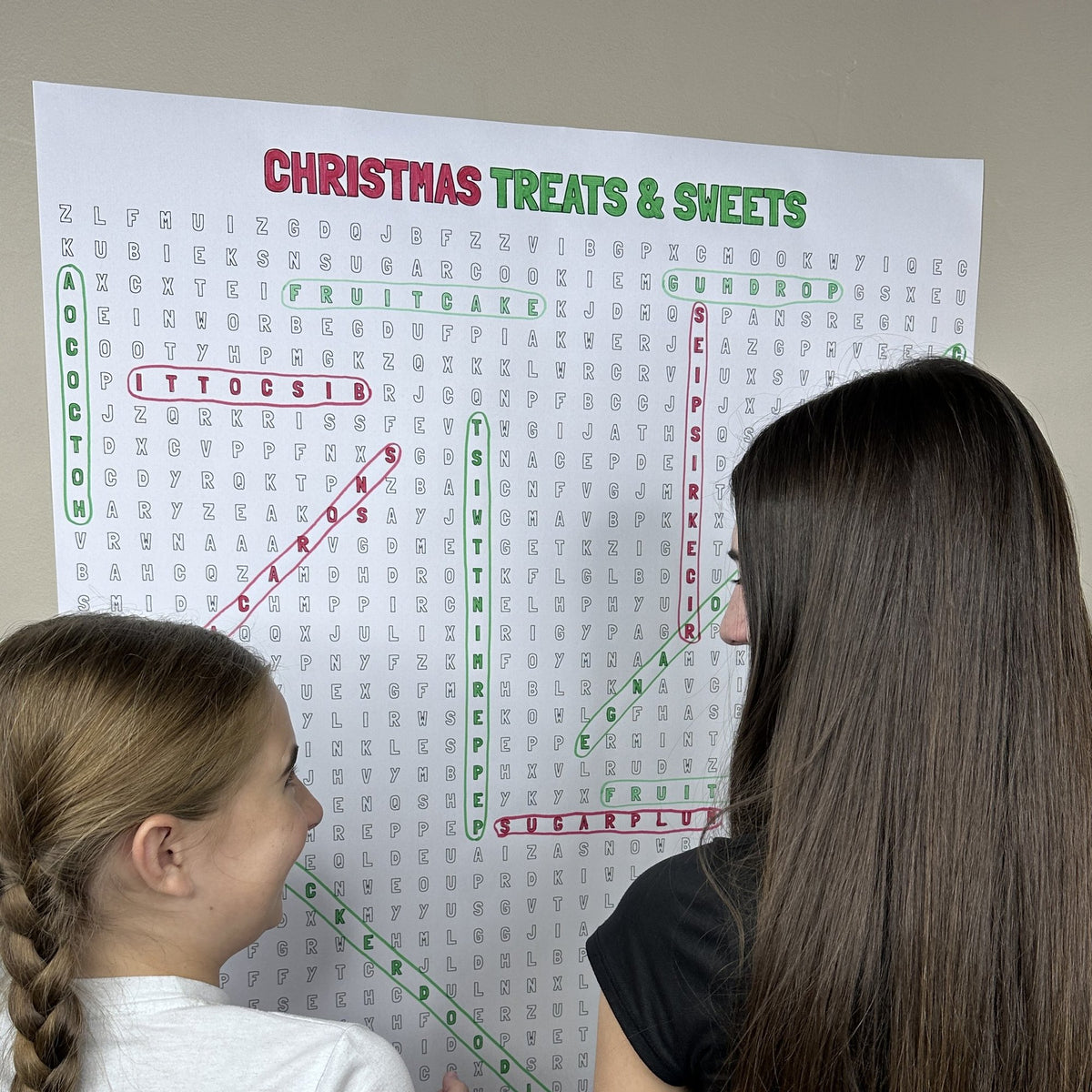 Kids circling words on the Christmas Treats Giant Word Search Puzzle at home