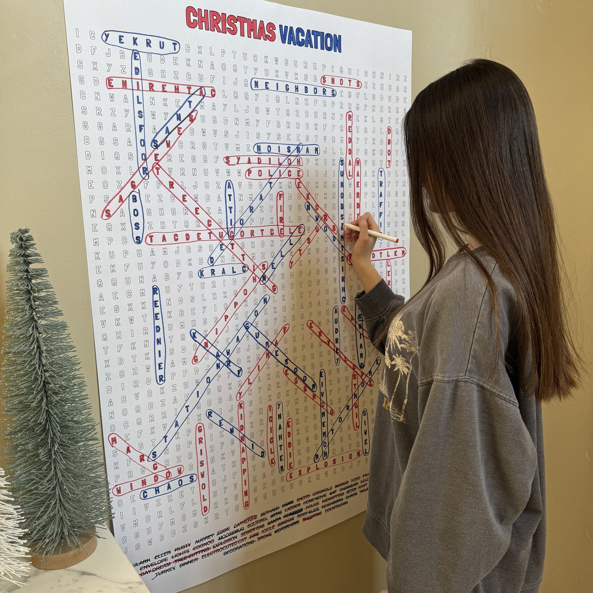 Kids circling words on the Christmas Vacation Giant Word Search Puzzle at home