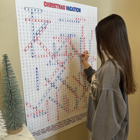 Kids circling words on the Christmas Vacation Giant Word Search Puzzle at home