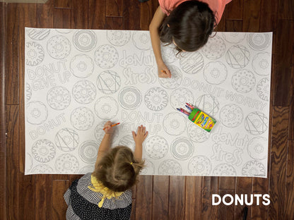 Child coloring the Donut giant coloring sheet on a wood floor with crayons