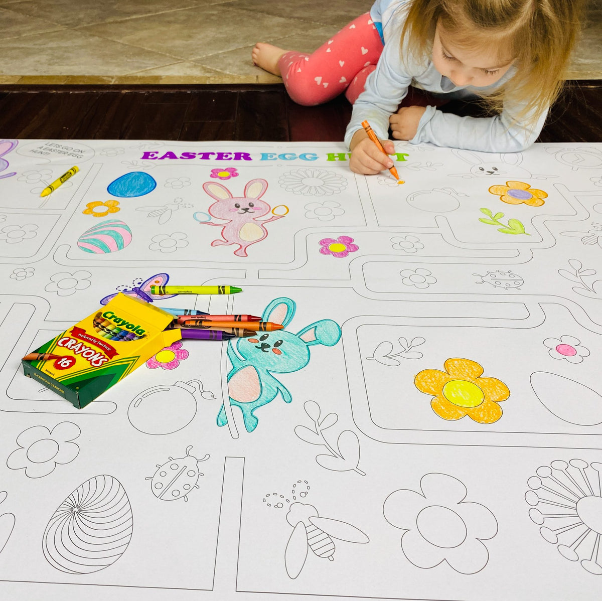 The Easter Egg Hunt giant coloring sheet being colored in with markers at a table