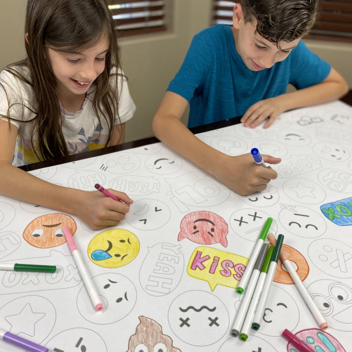 Kids coloring the Emoji Table Size Coloring Sheet at home