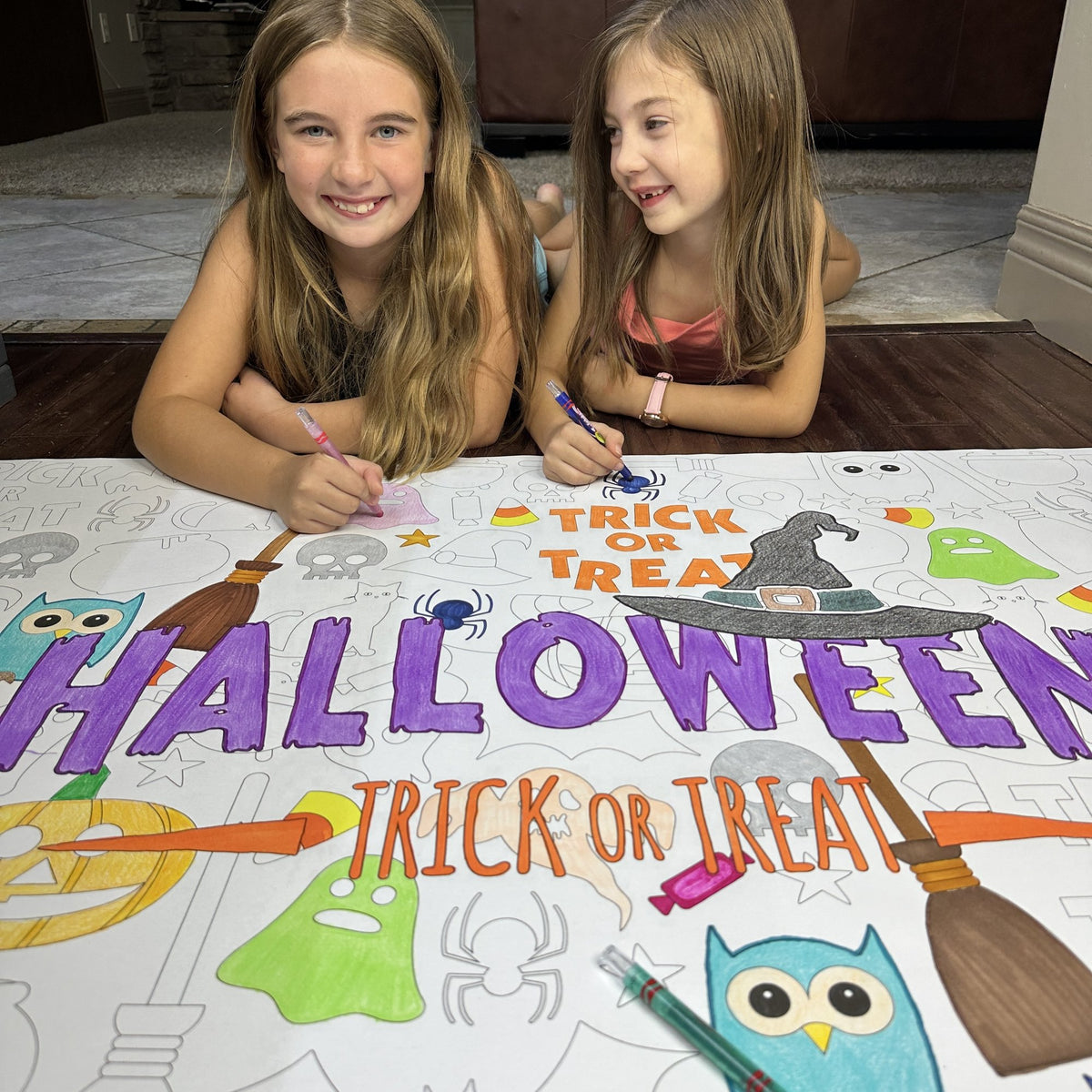 Kids coloring the Happy Halloween Table Size Coloring Sheet at home