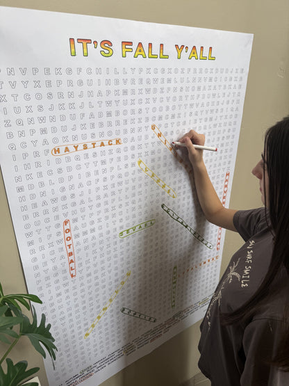 Girl circling words on the It's Fall Y'all Giant Word Search Puzzle, a giant 30x44.5 inch sheet on the wall