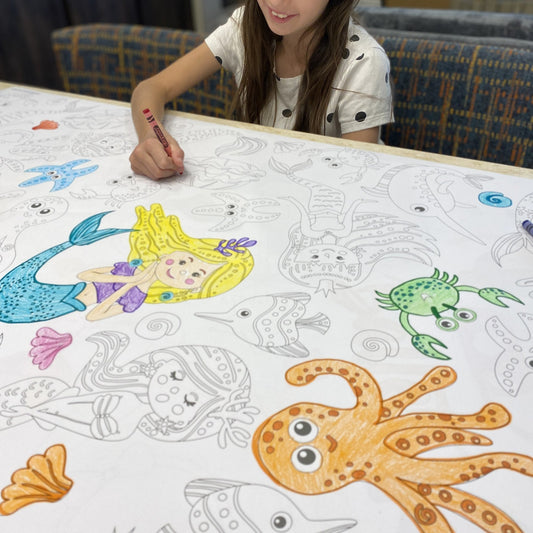 Kids coloring the Mermaids Table Size Coloring Sheet at home