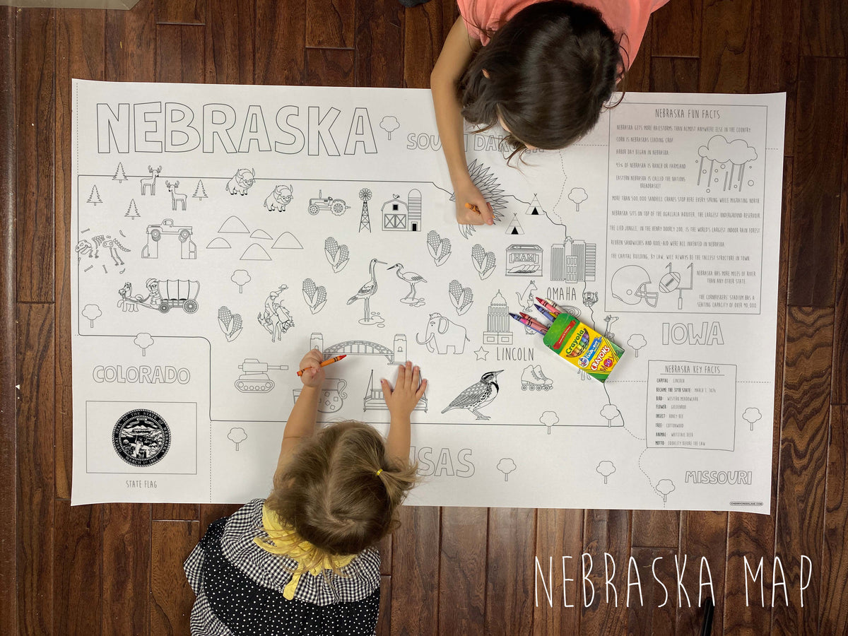 Child coloring the Nebraska state giant coloring map on a wood floor