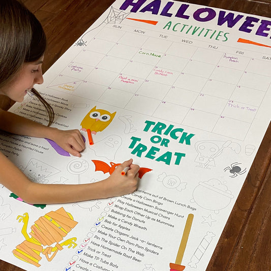 The Halloween Activity Calendar giant coloring sheet being colored in with markers at a table