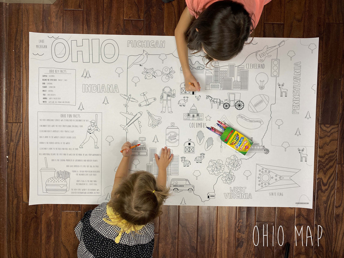 Child coloring the Ohio state giant coloring map on a wood floor