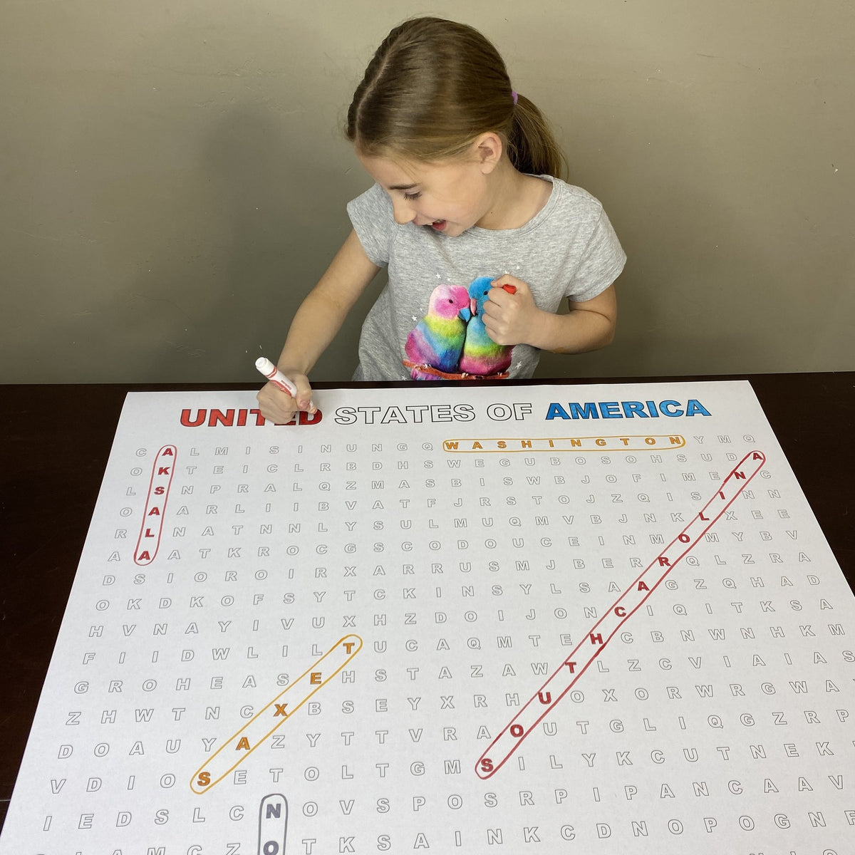 Kids circling words on the United States Giant Word Search Puzzle at home