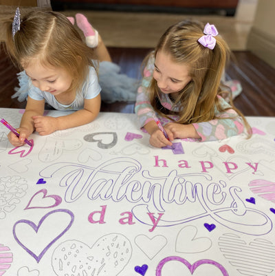 The Valentine Hearts giant coloring sheet being colored in with markers at a table