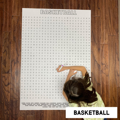 Child solving the Basketball giant word search poster on a wood floor
