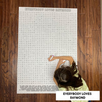 Thumbnail for Child solving a classic TV sitcom themed giant word search poster on a wood floor