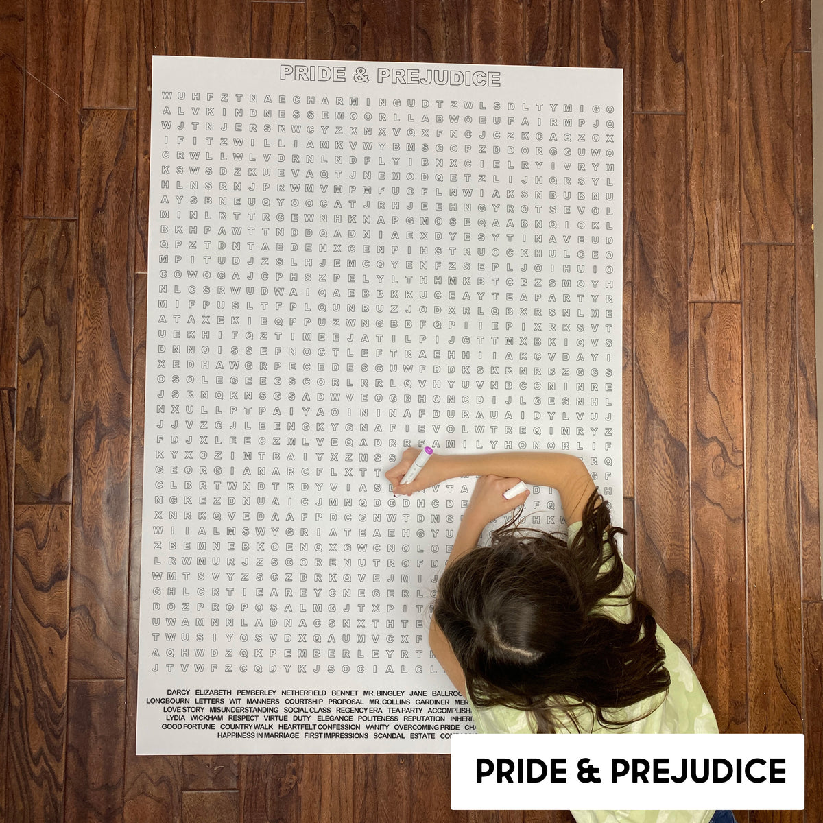Child solving the Pride & Prejudice giant word search poster on a wood floor