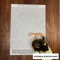 Thumbnail for Child solving the Stuffing & Stretchy Pants giant word search poster on a wood floor
