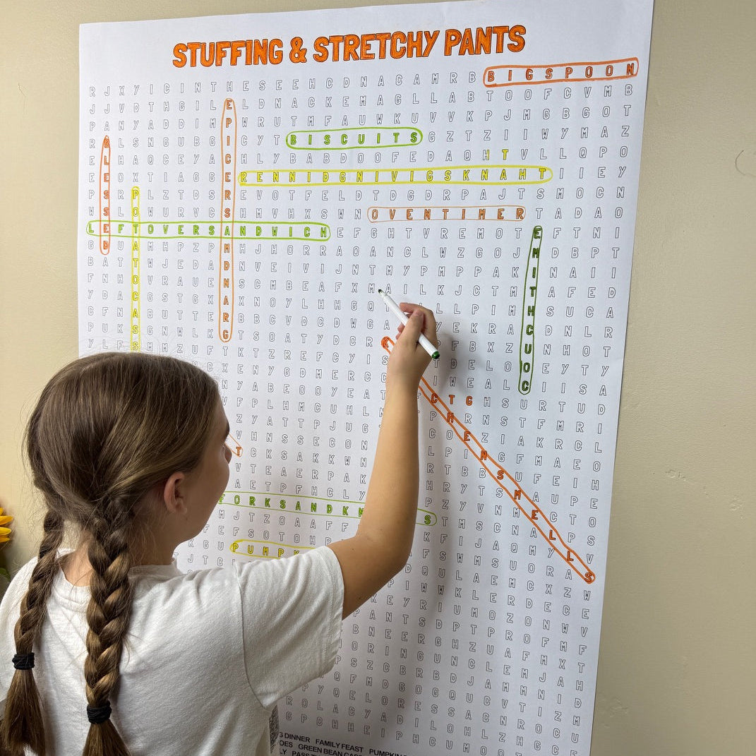 Kids circling words on the Stuffing & Stretchy Pants giant word search hung on a wall