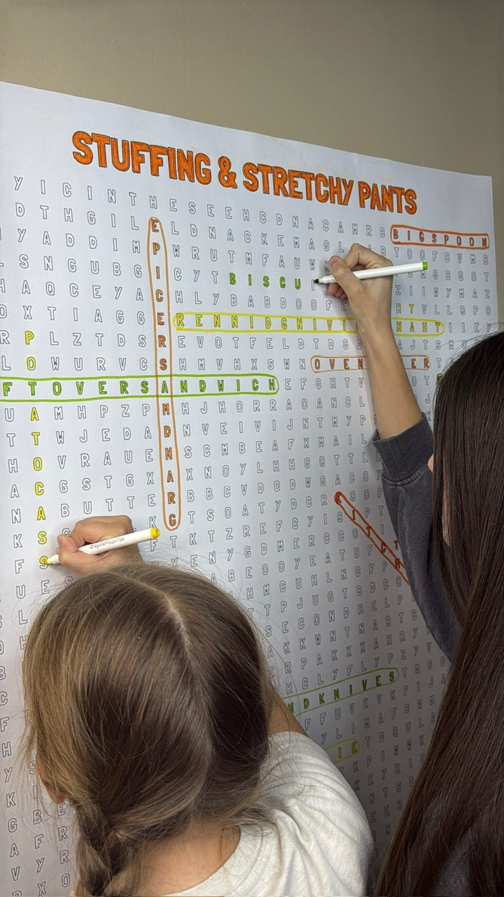 Kids circling words on the Stuffing & Stretchy Pants giant word search hung on a wall
