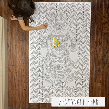 Child coloring the Zentangle Bear giant coloring sheet on a wood floor with crayons