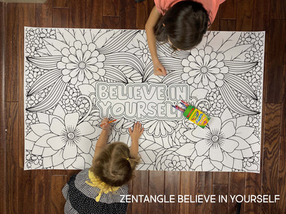 Child coloring the Zentangle Believe In Yourself giant coloring sheet on a wood floor with crayons