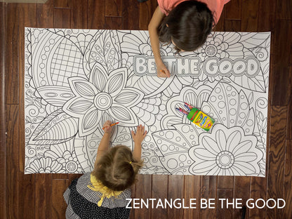 Child coloring the Zentangle Be The Good giant coloring sheet on a wood floor with crayons