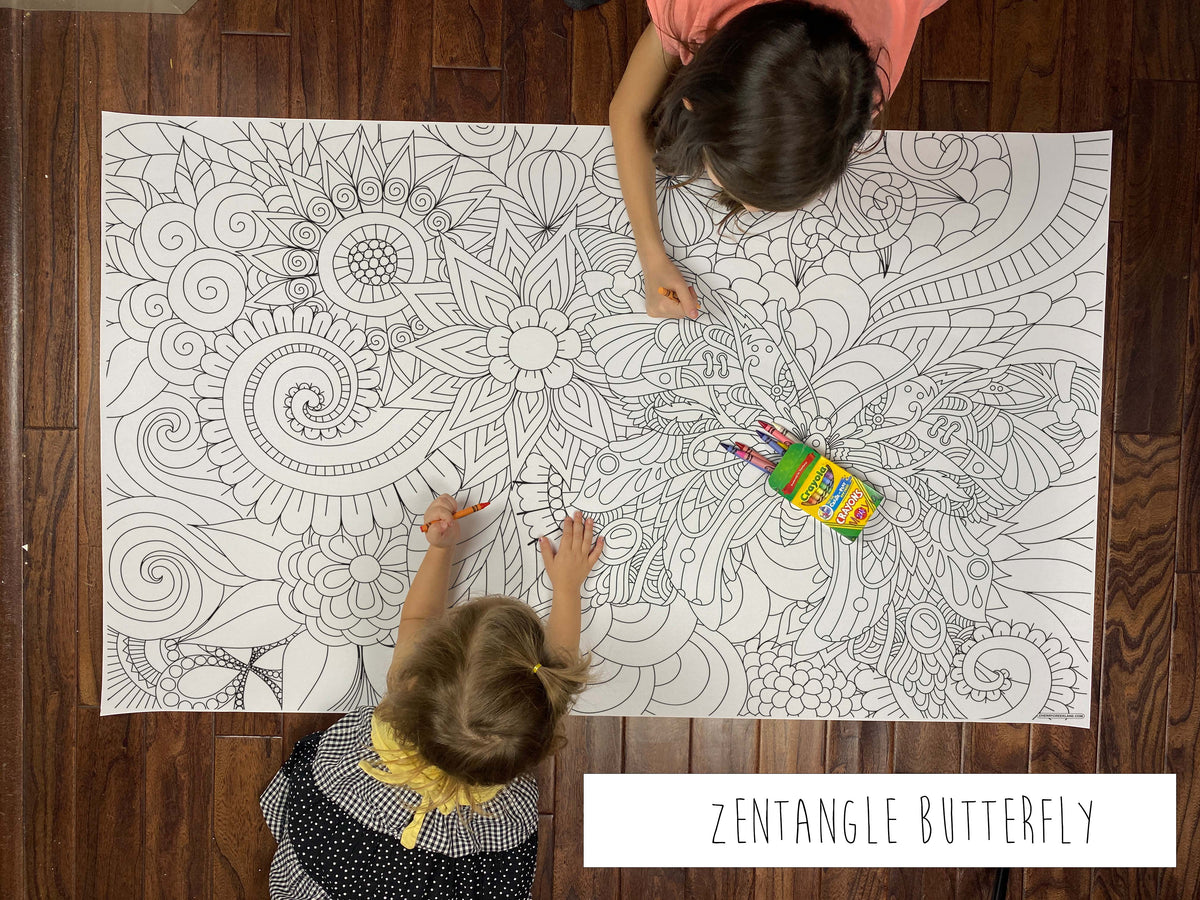 Child coloring the Zentangle Butterfly giant coloring sheet on a wood floor with crayons