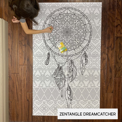 Child coloring the Zentangle Dreamcatcher giant coloring sheet on a wood floor with crayons