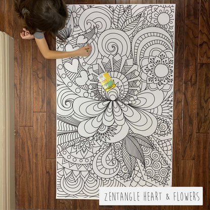 Child coloring the Zentangle Heart and Flower giant coloring sheet on a wood floor with crayons