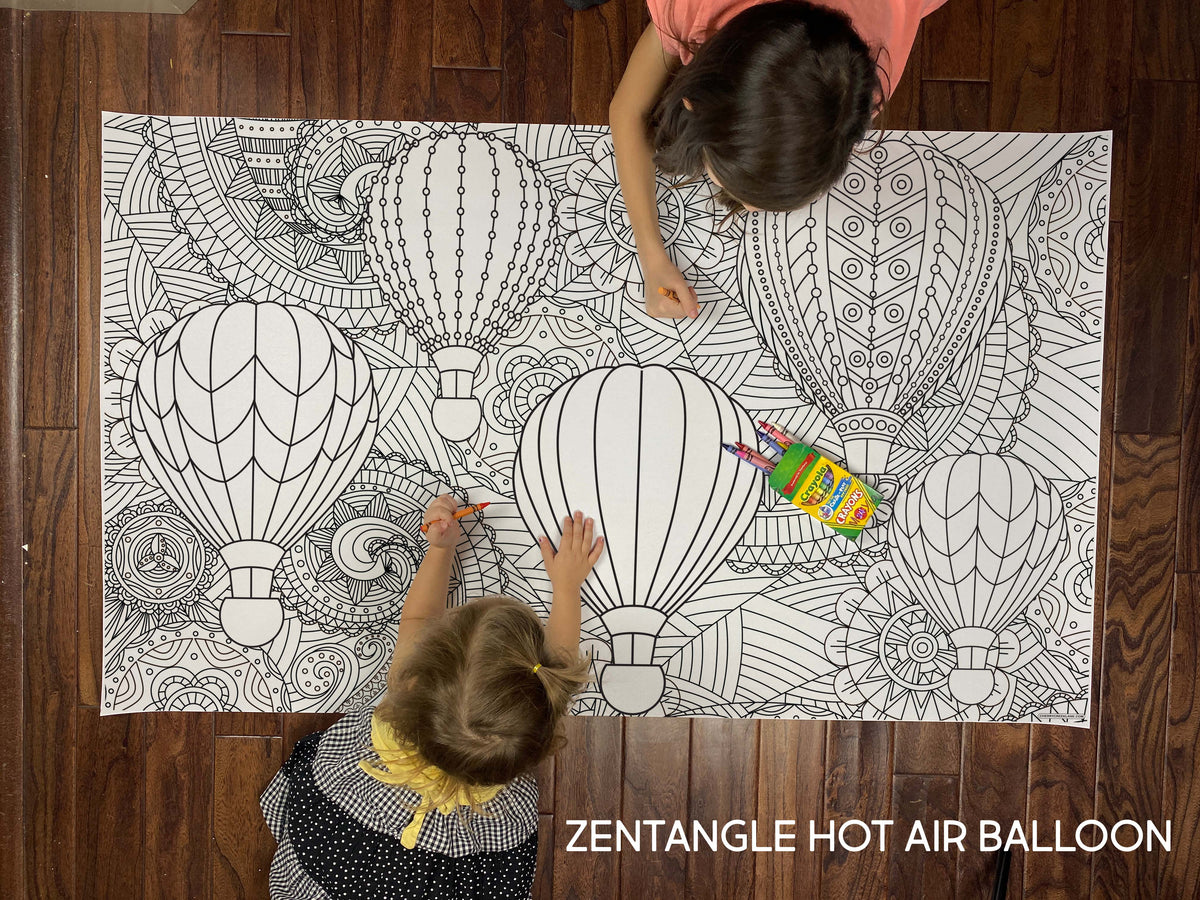 Child coloring the Zentangle Hot Air Balloon giant coloring sheet on a wood floor with crayons