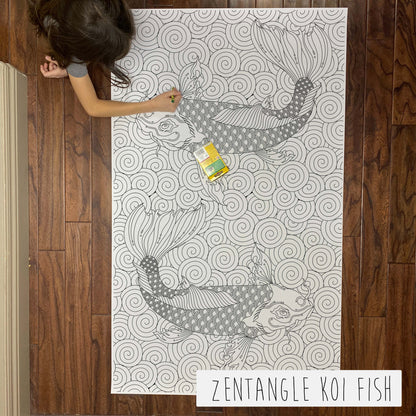 Child coloring the Zentangle Koi Fish giant coloring sheet on a wood floor with crayons