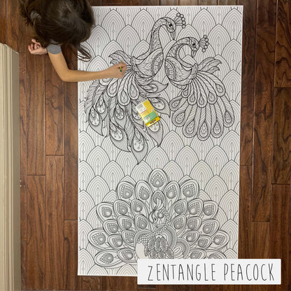 Child coloring the Zentangle Peacock giant coloring sheet on a wood floor with crayons