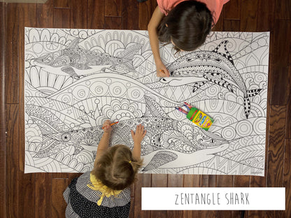 Child coloring the Zentangle Shark giant coloring sheet on a wood floor with crayons