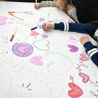 Thumbnail for The Love giant coloring sheet being colored in with markers at a table