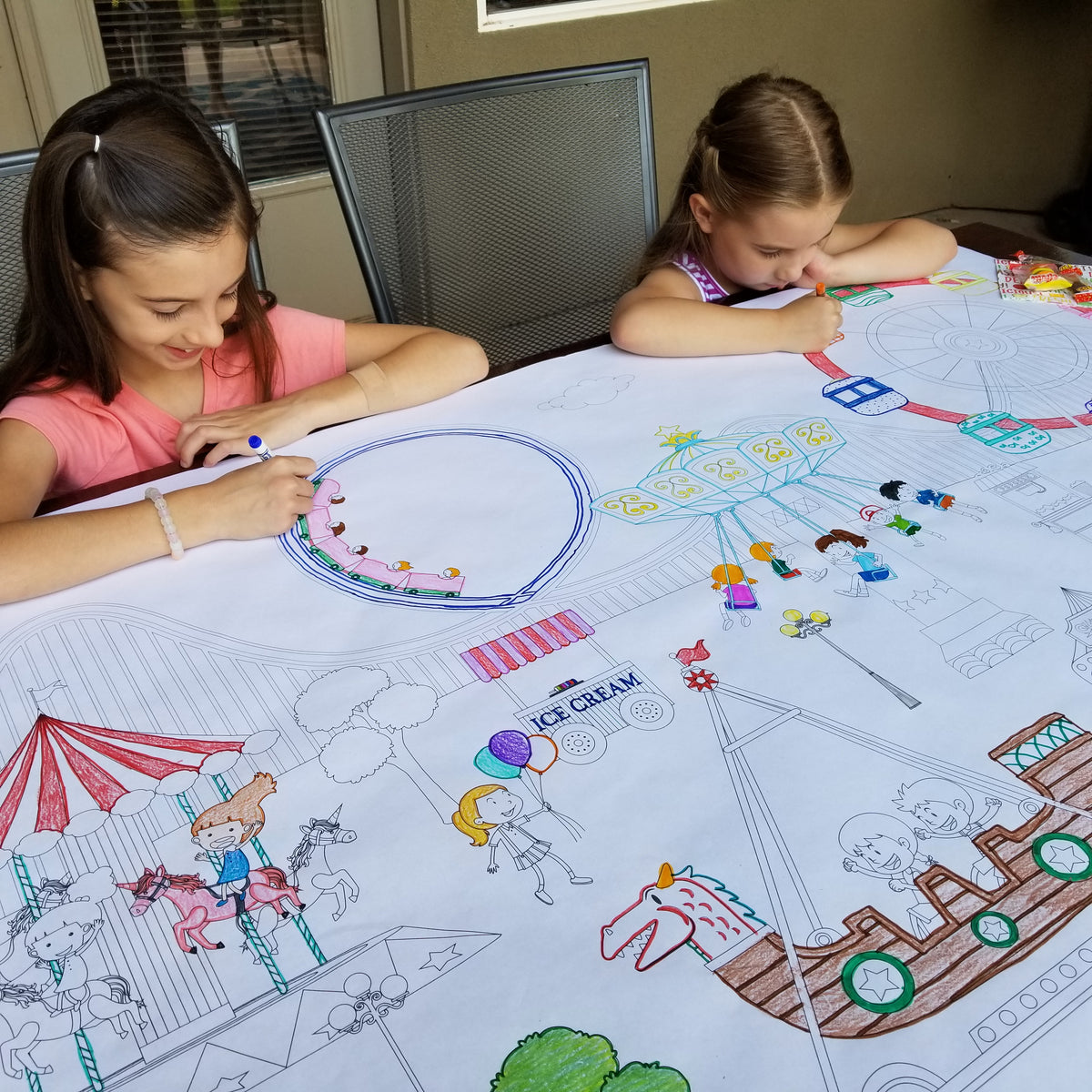 The Amusement Park giant coloring sheet being colored in with markers at a table
