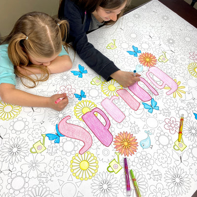 The Spring giant coloring sheet being colored in with markers at a table
