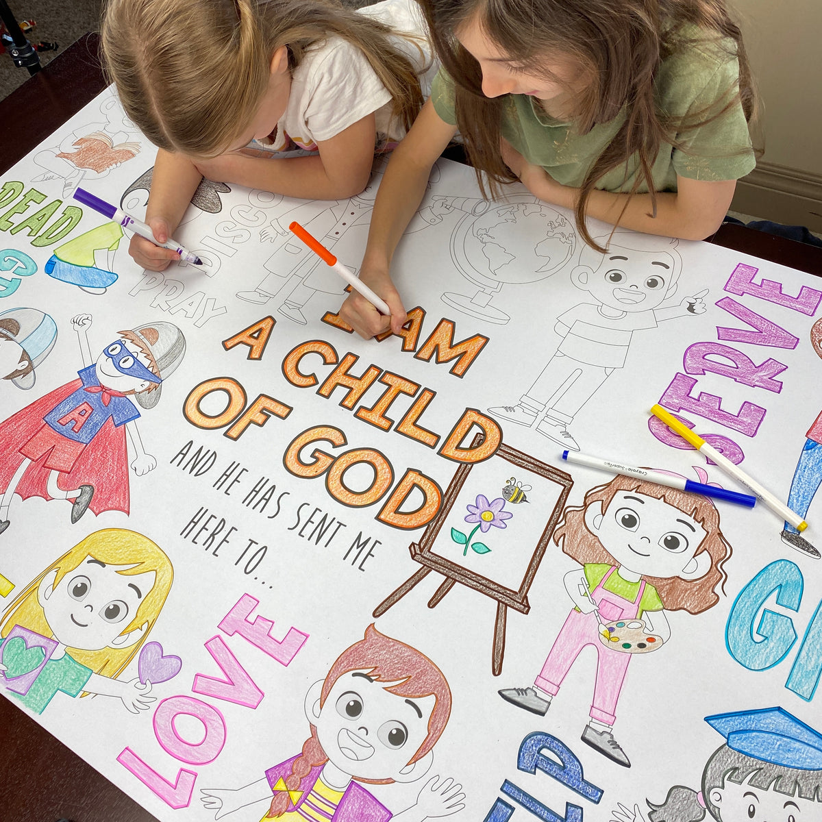 The Child of God giant coloring sheet being colored in with markers at a table